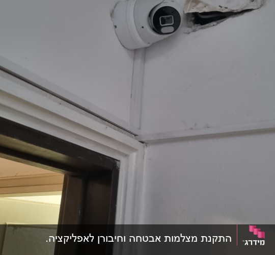 מצלמת אבטחה מותקנת בפינת תקרה עם חוטים חשופים